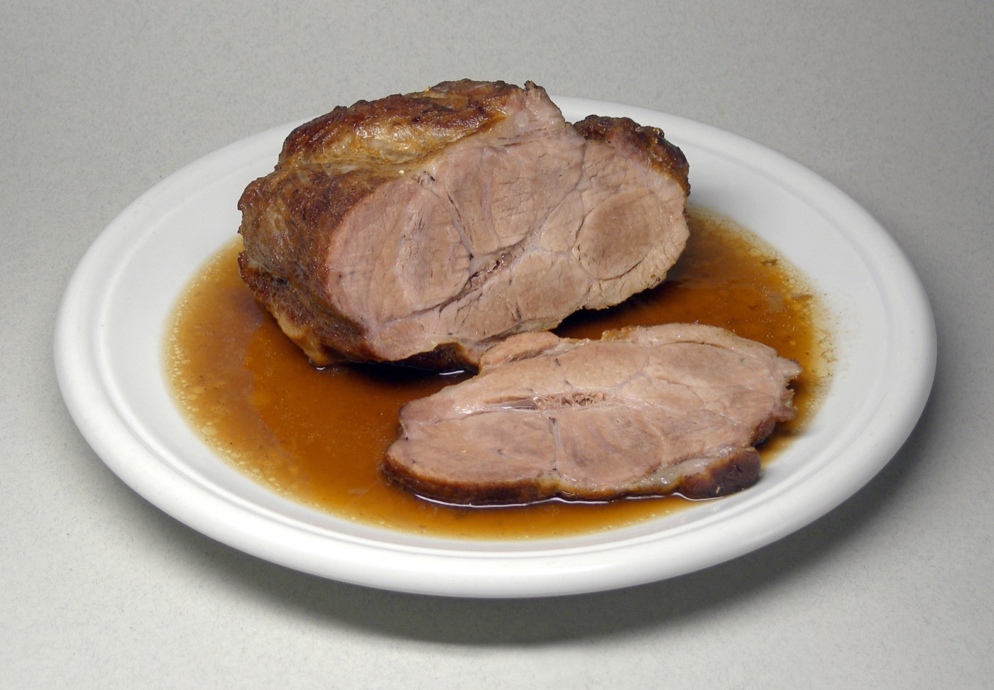 Roast pork with a deep browned exterior created by high-heat cooking